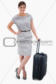 Woman standing next to wheely bag
