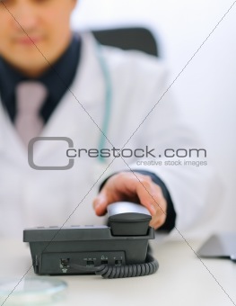 Closeup on doctors hand taking phone handset