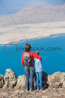 mother and daughter standing on cliff's edge