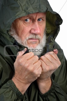 pathetic senior bearded man in green waterproof jacket