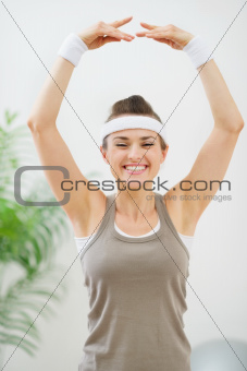 Smiling fitness woman making gymnastics exercise