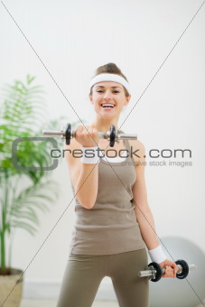 Healthy athletic woman making exercise with dumbbells