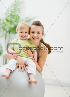 Portrait of happy mother and baby in gym