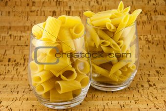Two varieties of pasta inside two transparent glasses