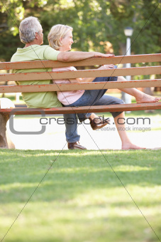 Senior Couple Sitting Together On Park Bench