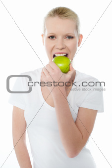 Healthy young girl eating nutritious green apple
