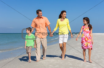 Mother, Father and Children Family Walking On Beach