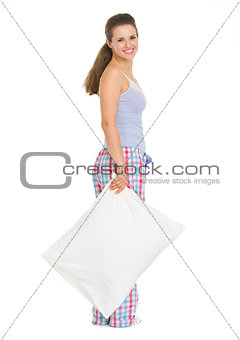 Full length portrait of young woman in pajamas with pillow