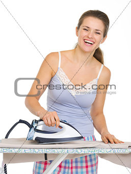 Young woman in pajamas ironing