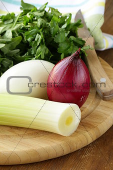 Various types of onions (leeks, red and white) on the cutting board