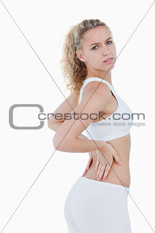 Young attractive woman touching her back