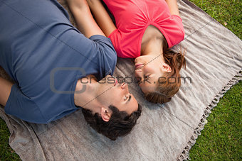 Two friends looking at each other while lying on a quilt