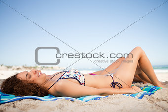 Young smiling woman lying on her beach towel with her friend