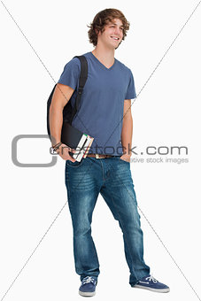 Male student with a backpack holding books