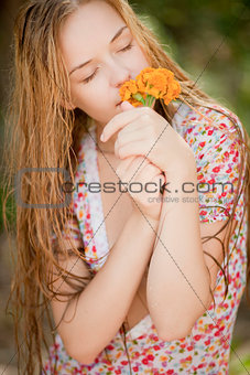 Village girl smelling flowers in nature