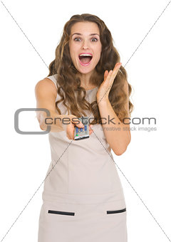 Surprised young woman with tv remote control