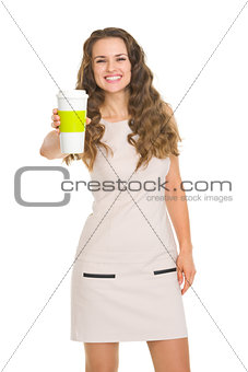 Smiling young woman giving coffee cup