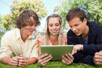 Three students using a touch pad