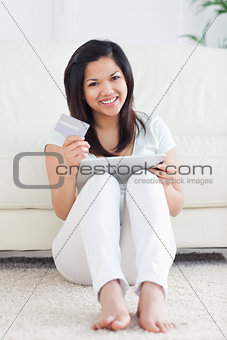 Woman holds a card and plays with a tactile tablet