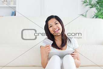 Woman laughs while she is holding a card and a tactile tablet