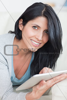 Close up of a smiling woman playing with a tablet