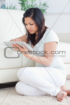 Woman holding a tactile tablet in front of a couch