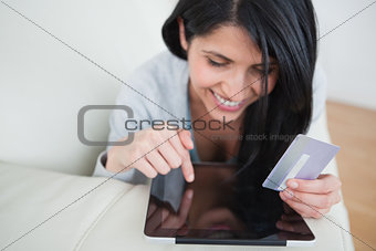Woman touching a tactile tablet and holding a credit card