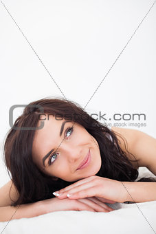 Calm woman lying on her white duvet