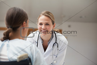 Smiling doctor looking at a patient on a wheelchair
