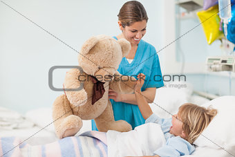Nurse showing a teddy bear to a child