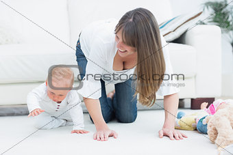 Mother on all fours next to a baby