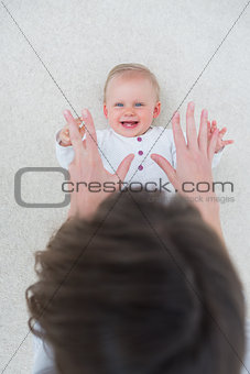 High view of a baby lying on back while playing