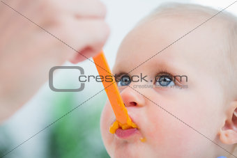 Baby looking at his mother while eating