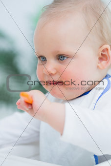 Baby holding a plastic spoon