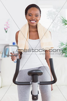 Black woman on bike holding a water bottle