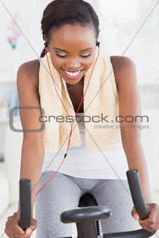Black woman on a bike listening music while smiling