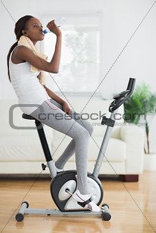 Side view of a black woman on an exercise bike