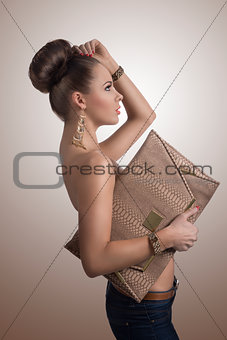 fashion brunette in jeans with big bag in profile
