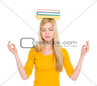 Student girl with books on head meditating