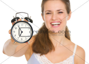 Closeup on alarm clock in hand of happy woman