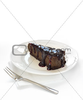 Slice of chocolate cheesecake on white plate