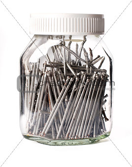 steel nails neatly stacked in a glass jar