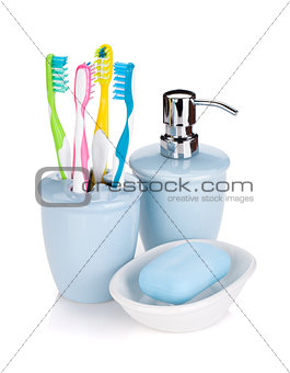 Four colorful toothbrushes and soap