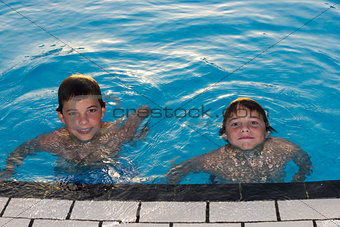 Activities on the pool. Cute boys swimming and playing in water 
