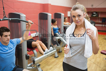 Smiling female trainer wearing towel around her neck