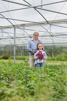 Man standing with granddaughter holding purple flowers