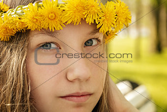 portrait of young teenager girl on bench with wreath of dandelions