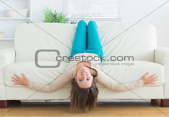 Funny woman lying upside down on sofa