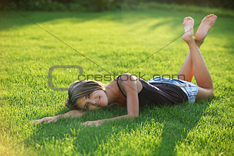 Young woman lying down on grass