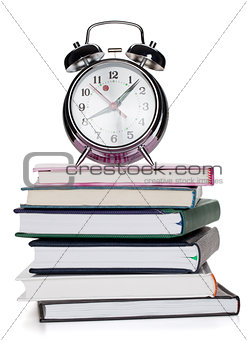 Alarm clock on notepads and books
